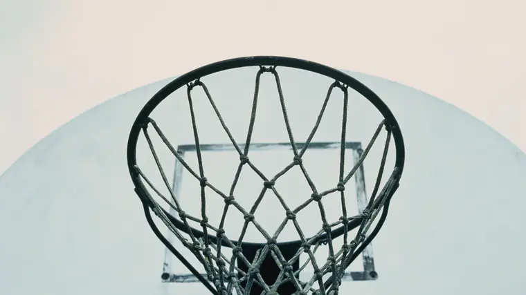 Cesto de basquetebol visto de baixo, com a rede em contraluz