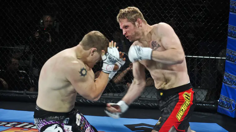 Dois lutadores de artes marciais mistas trocam golpes dentro da jaula