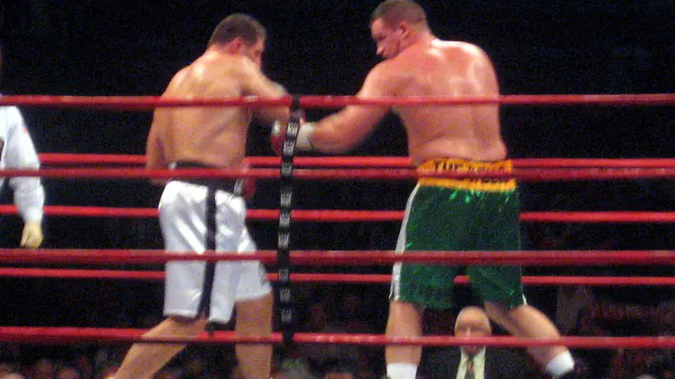 Combate de boxe num ringue iluminado