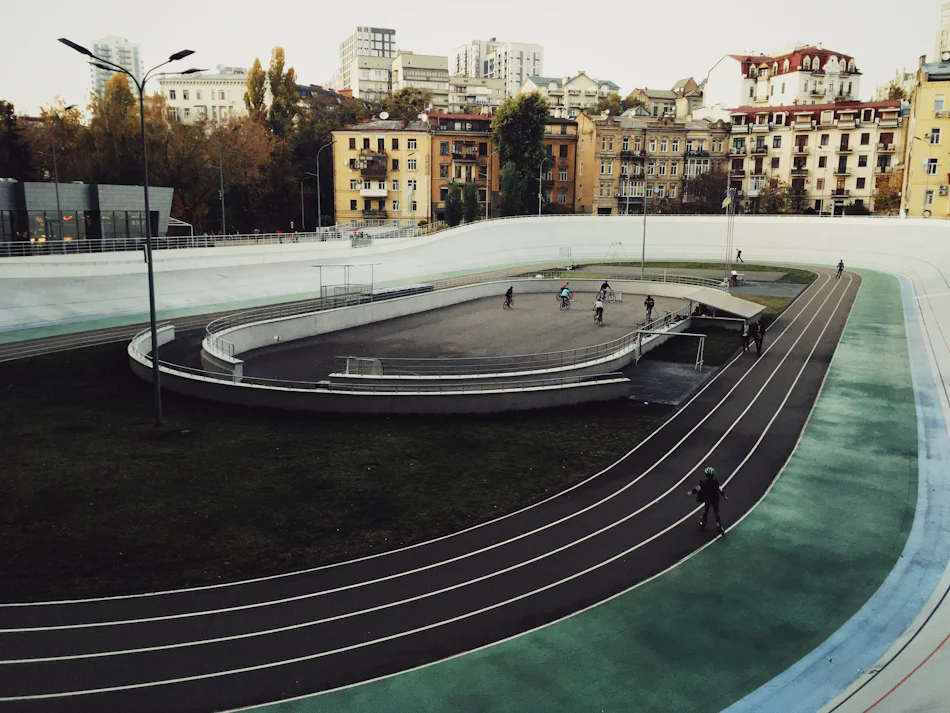 Velódromo ao ar livre vazio, com pista oval inclinada nas curvas e bancadas laterais